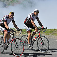 Two elderly cyclists riding towards the Col du Tourmalet in the Pyrenees, France