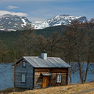 Log cabin with sod roof along lake at Fatmomakke, Lapland, Sweden